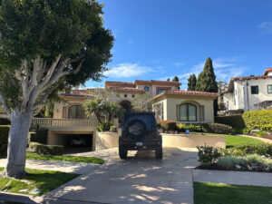 Newport Beach Luxury Home Sewage Backup Mold Inspection 1 A House With A Car Parked In Front, Showcasing A Suburban Setting With A Well-Maintained Lawn.