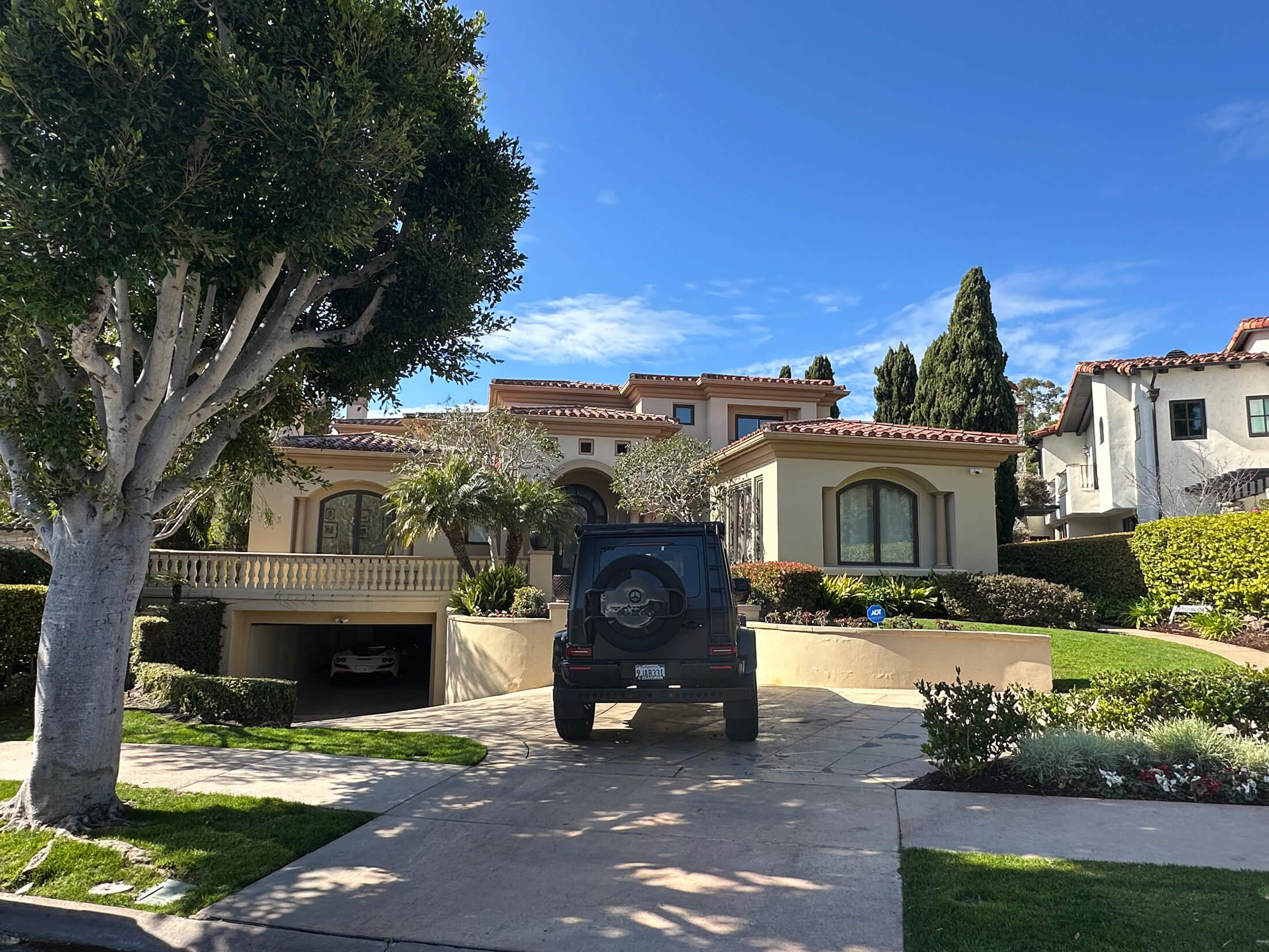A house with a car parked in front, showcasing a suburban setting with a well-maintained lawn.